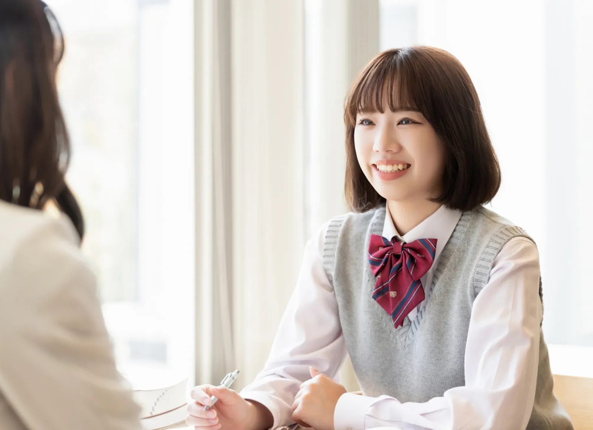 制服姿の高校生が講師と面談している様子